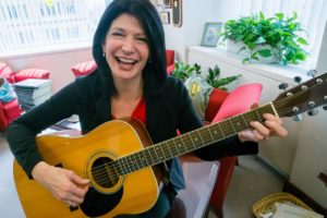 In this photo taken Sept. 19, 2014, National Education Association (NEA) President Lily Eskelsen Garcia poses with her guitar after an interview with The Associated Press in her office at NEA headquarters in Washington. (AP Photo/J. David Ake)